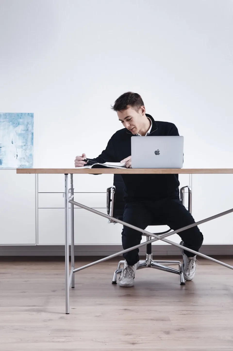 Mitarbeiter von THEFABERS am Schreibtisch mit Laptop und Notizbuch