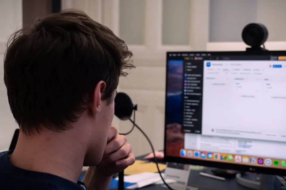 Arbeitsplatz mit Monitor und Headset, an dem eine Kampagne ausgewertet wird